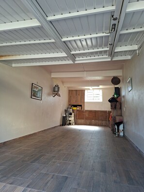 A spacious room with a high ceiling, wooden flooring, and a large window allowing natural light. - New Listing (Bento Gonçalves)