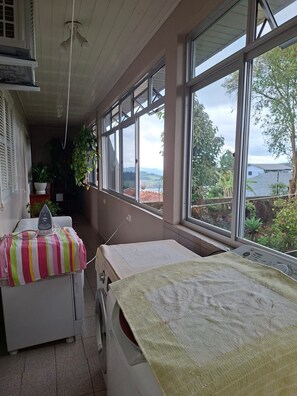 A laundry room with a washing machine, an iron, and a drying rack. - New Listing (Bento Gonçalves)