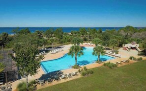 A resort with a swimming pool, lounge chairs, and a view of the ocean. - Spacious 3 bedroom house + 1 bedroom Mother-in-law suite with its own entrance (Port St. Joe)