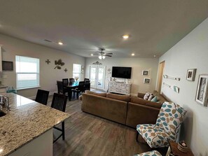 A modern living room with a dining area, a kitchen island, and a ceiling fan. - Spacious 3 bedroom house + 1 bedroom Mother-in-law suite with its own entrance (Port St. Joe)