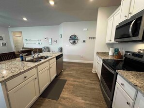 A kitchen with a granite countertop, stainless steel appliances, and a microwave. - Spacious 3 bedroom house + 1 bedroom Mother-in-law suite with its own entrance (Port St. Joe)