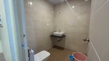 A small bathroom with a toilet, a sink, and a shower.