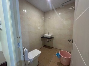 A small bathroom with a toilet, a sink, and a shower.