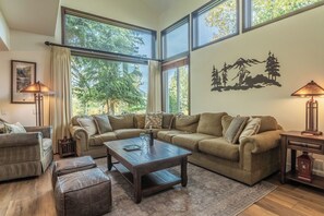 A spacious living room with a large sectional sofa, a wooden coffee table, and a patterned rug. - Communal Hot Tub | Fireplace (Mammoth Lakes)