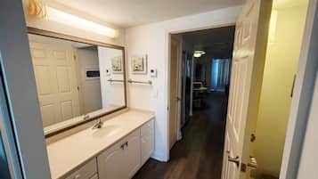 Bright vanity area with large mirror, storage, and easy suite access
