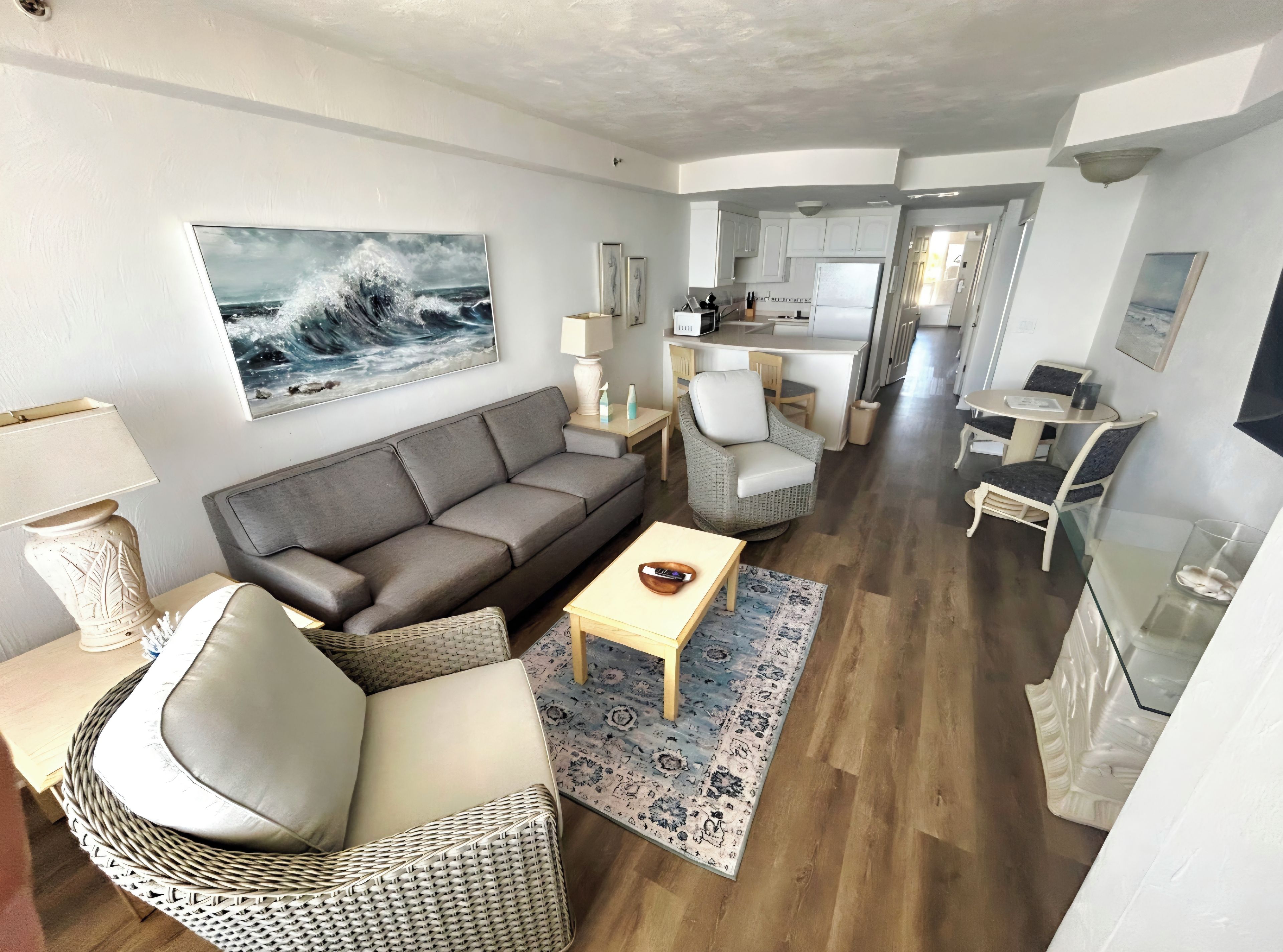 Bright coastal living room with open layout, dining nook, and beachy decor