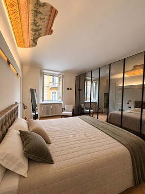 A bedroom with a large bed, a wardrobe, a window, and a radiator. - Apartment in the City Centre 'Vittorio Amedeo II Apartment' (Torino)