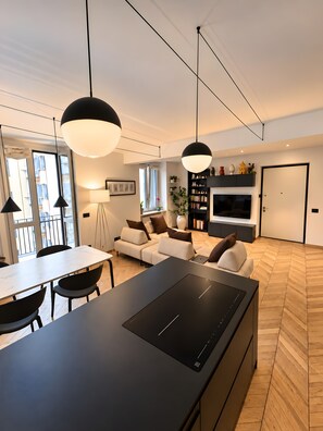 A modern living room with a dining area, a flat-screen TV, and a large window. - Apartment in the City Centre 'Vittorio Amedeo II Apartment' (Torino)