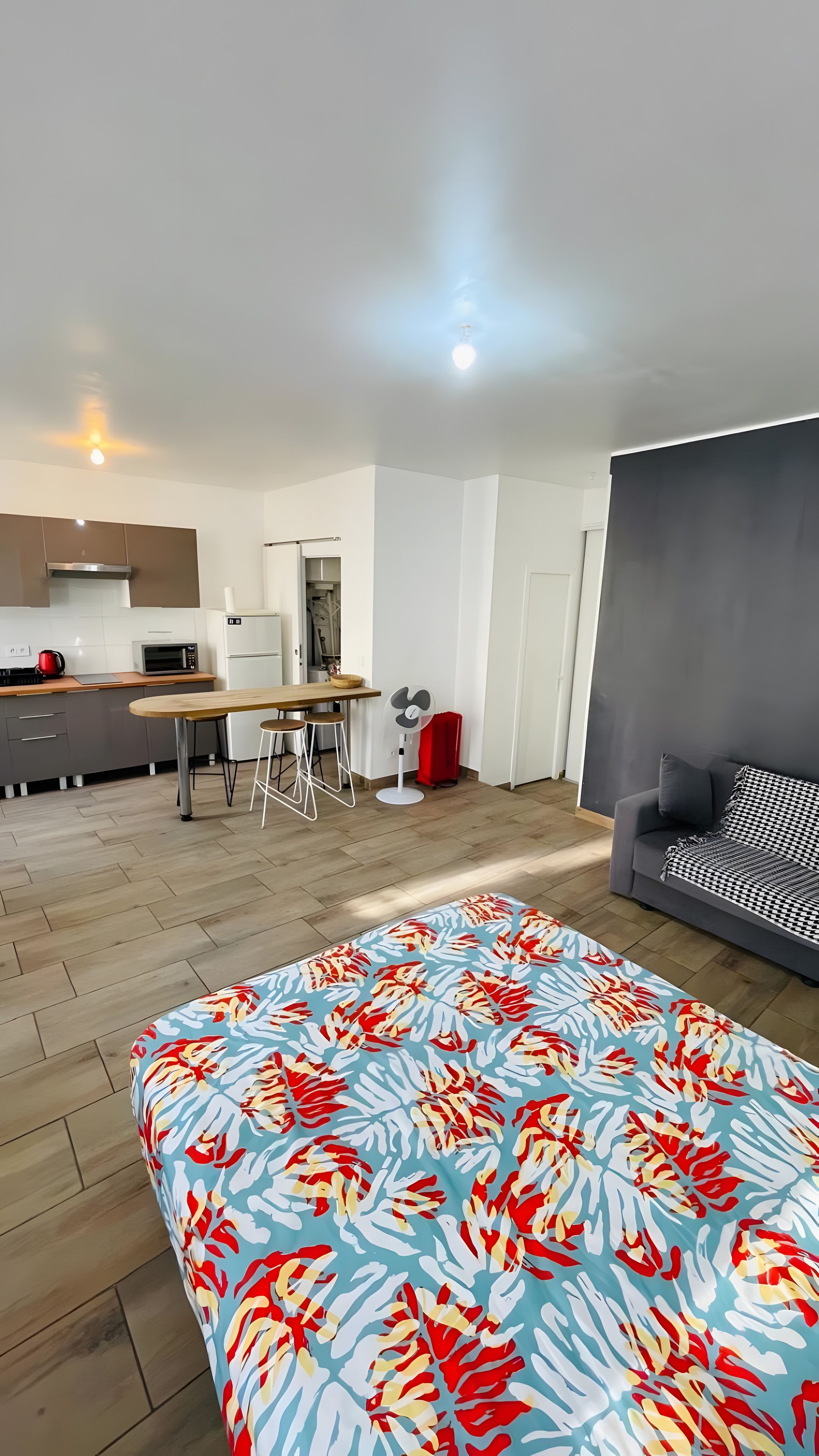 Une chambre moderne comprenant un lit, un canapé, un coin repas et une cuisine.