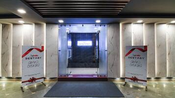 A hotel entrance with a marble floor, a glass door, and two banners on either side.