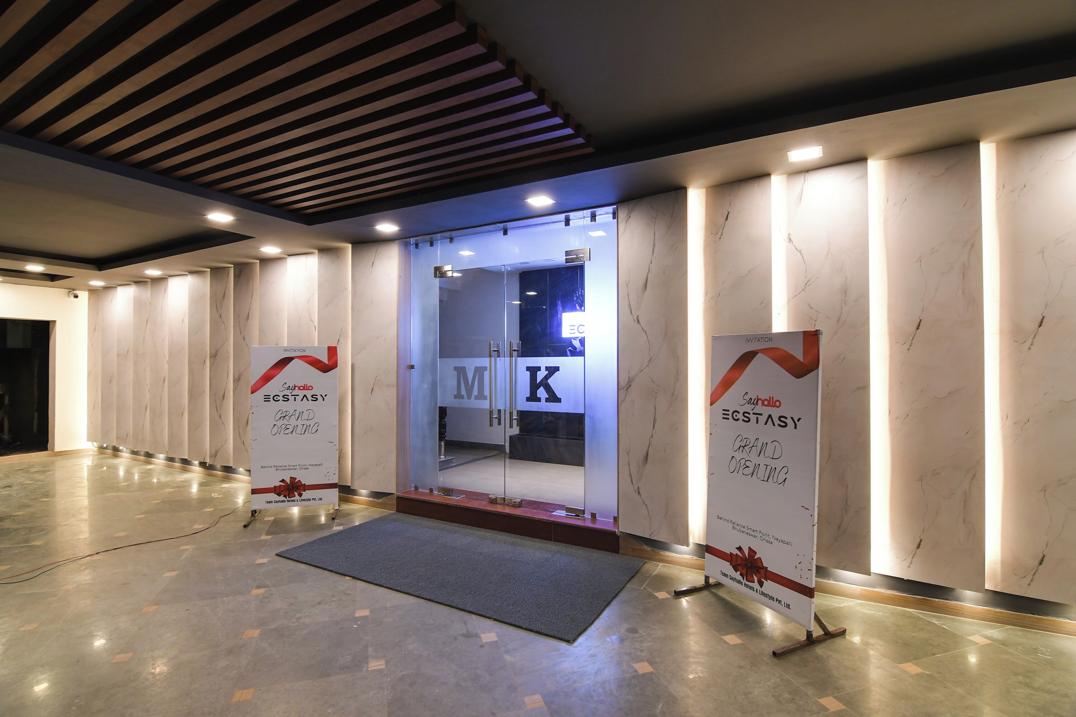 Ein Hotel Eingang mit einem großen Eröffnungsbanner, einer Rezeption und einem modernen Innenraumdesign.