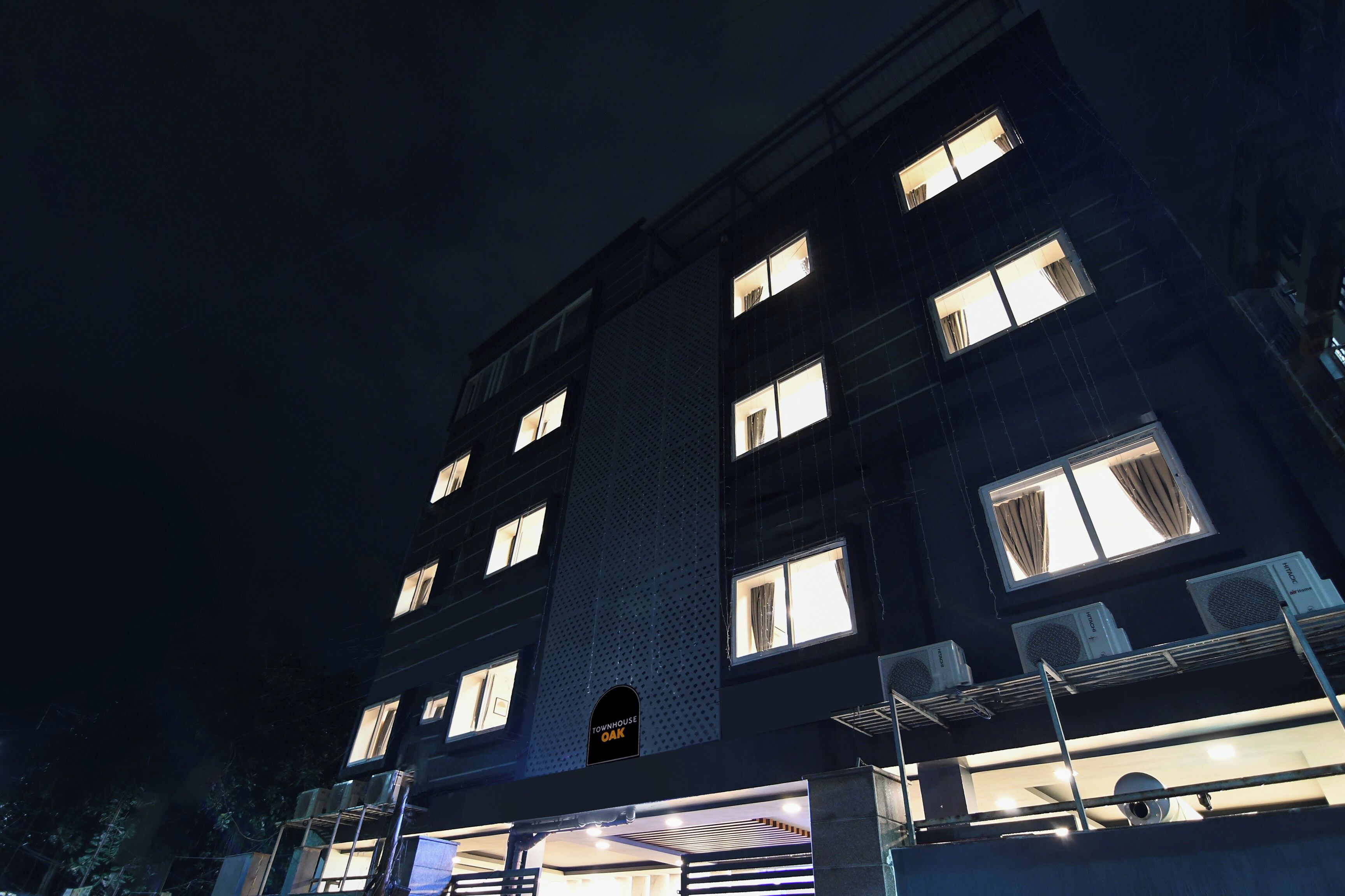 A multi-story building with illuminated windows at night.