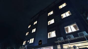 A multi-story building with illuminated windows at night.