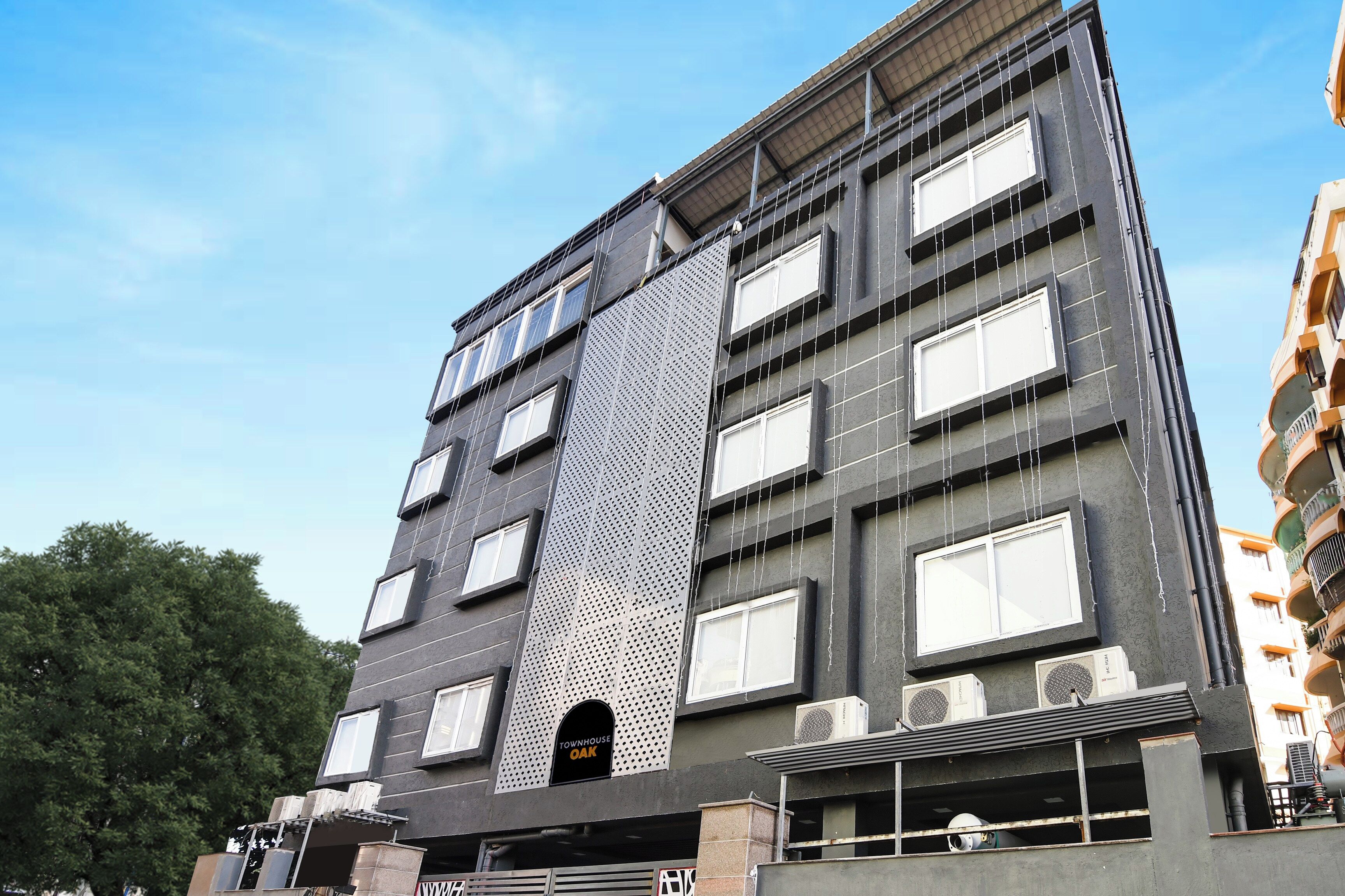 A multi-story building with a modern architectural design, featuring a prominent vertical element and multiple windows.