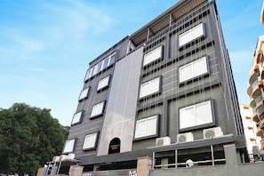 A multi-story building with a modern architectural design, featuring a prominent vertical element and multiple windows.
