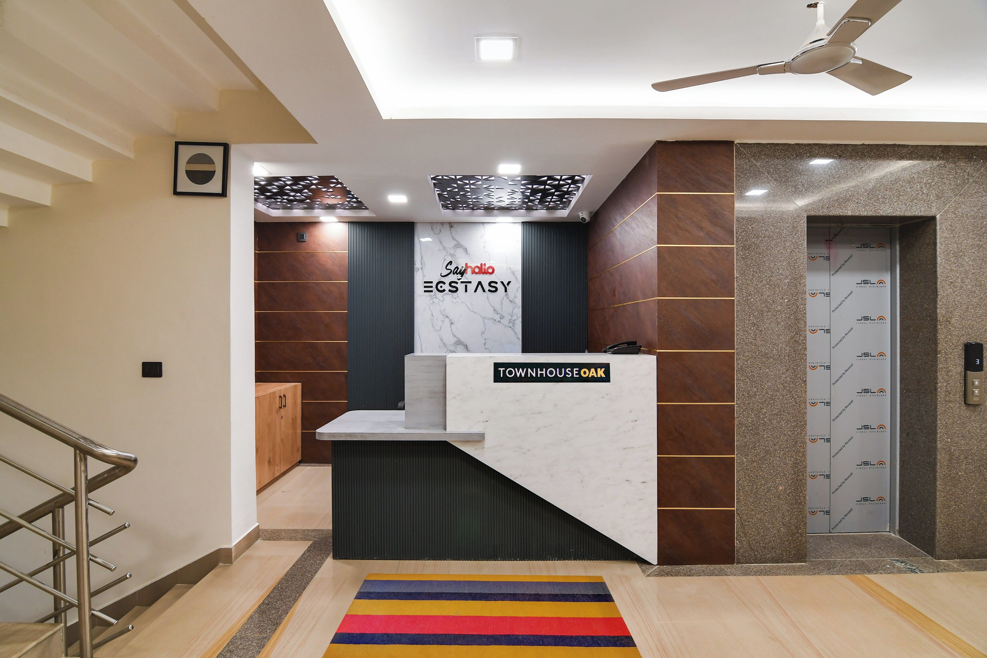 A reception desk with a sign reading 'Townhouse Oak' and a 'Say hi' sign above it.