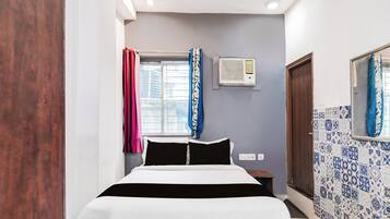 Un dormitorio con cama, ventana con cortinas, unidad de aire acondicionado y pared con azulejos.