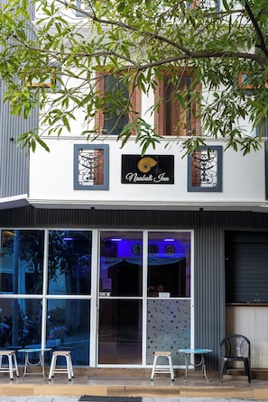A two-story building with a sign reading 'Naaboli Inn.' - Naaboli Inn (Hulhumale)