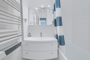A bathroom with a white sink, a mirror, a shower curtain, and a ventilation system. - Apartment 'Le Jardin Canisy - Piscine - Tennis' with Shared Pool, Private Terrace and Wi-Fi (Saint-Arnoult)