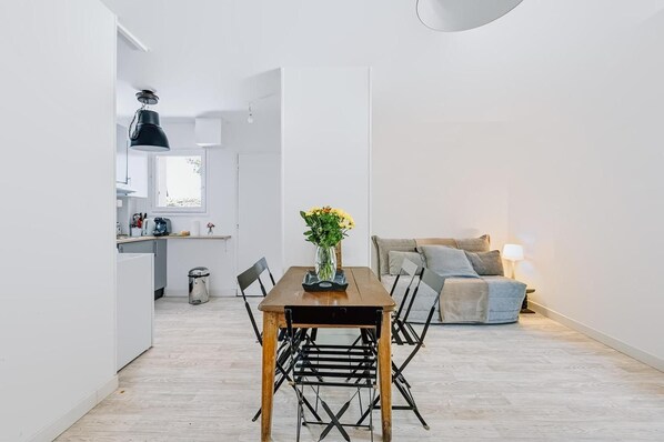 A modern apartment with a dining area, kitchen, and living space. - Apartment 'Le Jardin Canisy - Piscine - Tennis' with Shared Pool, Private Terrace and Wi-Fi (Saint-Arnoult)