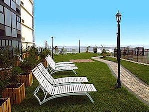 Outdoor lounge chairs, a pathway, and a lamp post. - Oceanview Deluxe Studio w/pool & kitchenette (Daytona Beach)