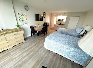 Een slaapkamer met een bed, een dressoir, een bureau en een stoel.