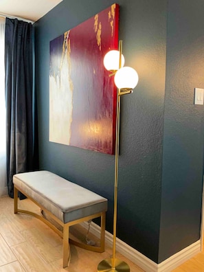 A room with a bench, a floor lamp, and a large abstract painting on the wall. - Updated Old Town 1st Fl Parking Pool Spa Hot Tub (Scottsdale)