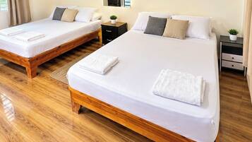 Une chambre d’hôtel avec deux lits, un plancher en bois et un miroir au mur.