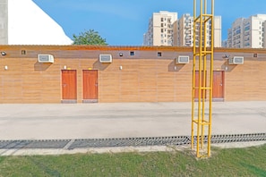 Un edifici amb teulada plana, dues portes de fusta i diverses unitats de aire condicionat.
