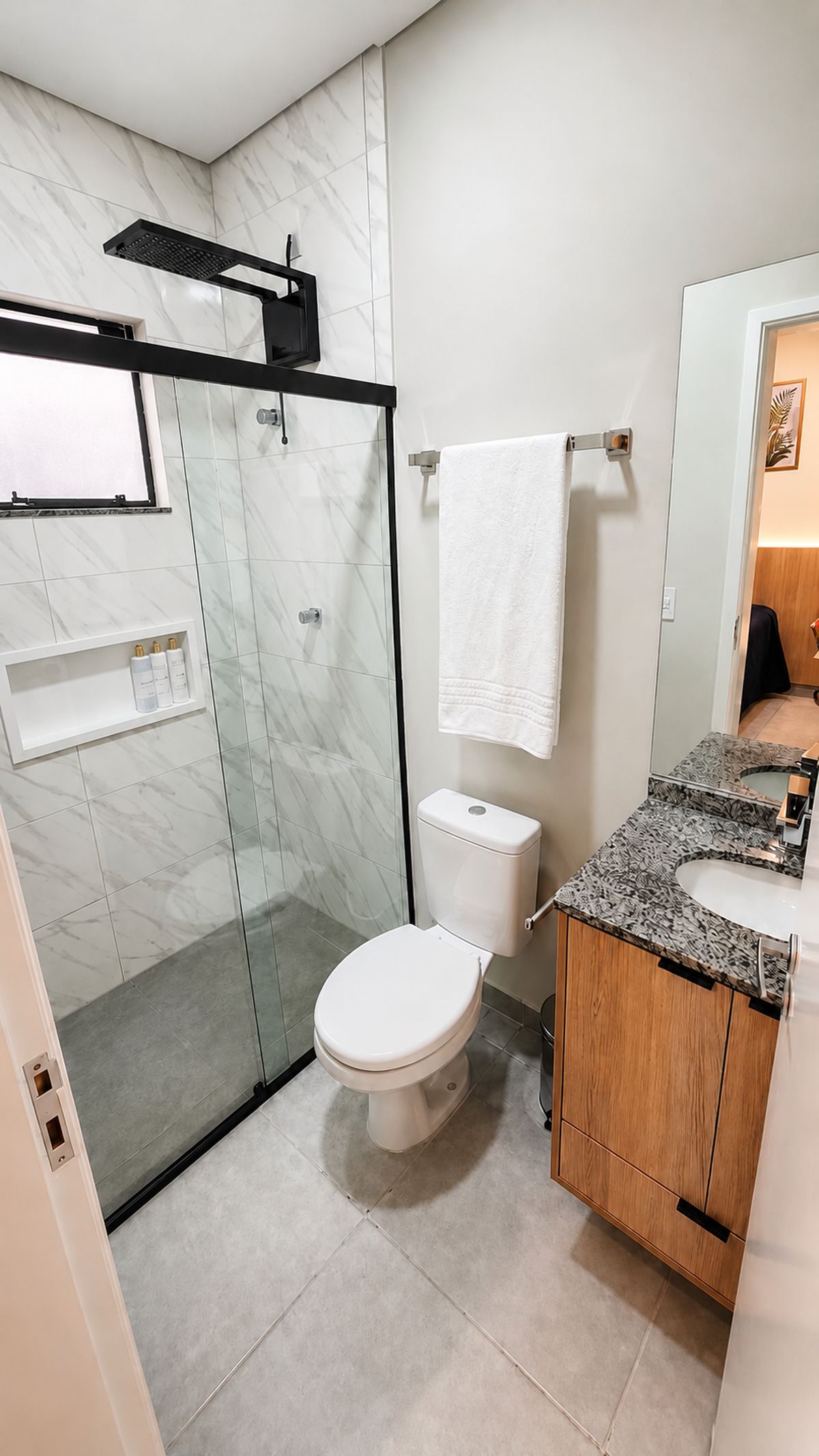 A modern bathroom with a glass-enclosed shower, a toilet, and a vanity with a sink.