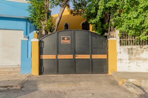 A gated entrance with a 'NO ESTACIONARSE' sign, a blue building, and a yellow wall. - Beautiful 5-bedroom Colonial house with pool in Historic Centro Mérida (Mérida)