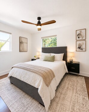A bedroom with a bed, a ceiling fan, bedside tables, and artwork on the walls. - Fully Furnished 3BR + Bonus Room, Golf Course, Horseshoe Bay (Horseshoe Bay)