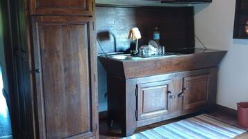 A kitchen with wooden cabinets, a countertop, and a hanging light fixture.