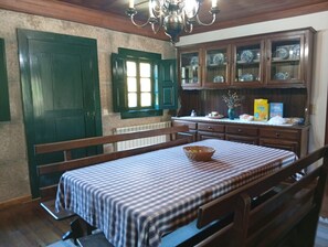 A dining area with a table set for two, a bench, and a window with shutters. - Room 'Suite 2' with Mountain View, Shared Garden and Wi-Fi (Soajo)