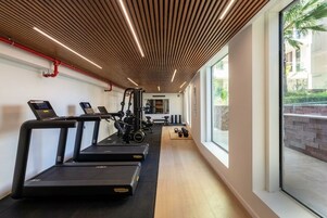 A gym with treadmills, weight machines, and exercise balls.