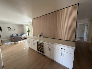 A modern kitchen with white cabinetry, a built-in oven, and a large island with a countertop. - Brand-New Renovated 4BR/2BA l Prime Hayward Location (Hayward)