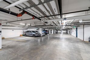 A multi-level parking garage with cars parked on different levels. - `Auburn` 1 King  1 Queen Bed | UG Parking | Sofa Bed (Calgary)
