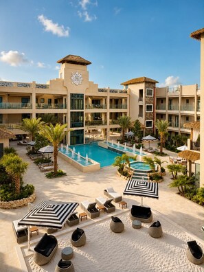 A hotel with a swimming pool, lounge chairs, and umbrellas. - Sunrise & Sunset 1BR | 5 Min to Eagle Beach (Noord)