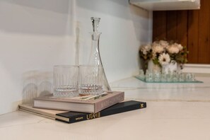 Een boek met de titel 'Made for Living' op een tafel met twee glaasjes en een decanteerkaraf.