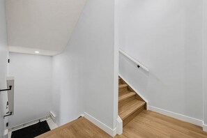 Una escalera con escalones de madera y paredes blancas.