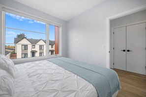 A bedroom with a bed, a window, and a door. - `The Juniper` 3 Bed | King | Garage | 5 Min to DT (Calgary)