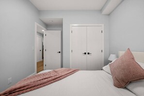 A bedroom with a bed, a bedside table, a lamp, and a wardrobe. - `Paris` King Bed | 7 Mins to DT + Free Parking (Calgary)