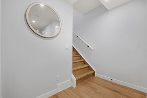 Una escalera con escalones de madera y una pared blanca.