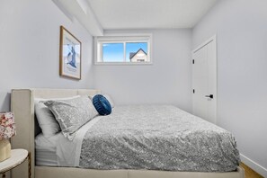 A bedroom with a bed, a window, a door, and a framed picture on the wall. - `Greece` King Bed | Private Suite + 7 Min to DT (Calgary)