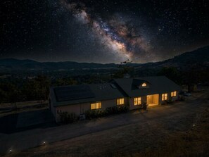 Ein Haus mit geneigtem Dach, einer Garage und einer Auffahrt.