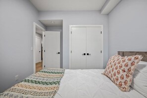 A bedroom with a bed, a patterned blanket, a pillow, and a wardrobe. - `Stampede` King Bed | 7 Min to Downtown + Parking (Calgary)