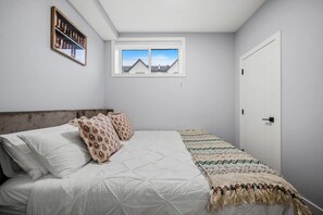 A bedroom with a bed, pillows, a window, and a door. - `Stampede` King Bed | 7 Min to Downtown + Parking (Calgary)