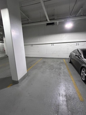 Eine Parkgarage mit nummerierten Stellplätzen, ein Auto auf Platz 25 und Betonstützen.
