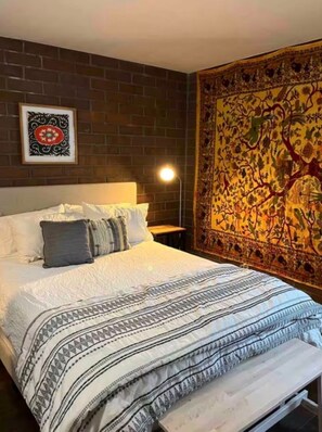 A bed with a patterned bedspread, a headboard, and a wall tapestry. - OG Park City Vibe! 2 bedroom + hot tub (Park City)