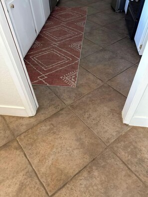 A hallway with a patterned rug and tiled flooring. - Hot tub I Fire pit I 10 min to park I 5 min to JT (Joshua Tree)